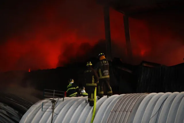 Bomberos sobre el techo de una bodega aledaña al incendio de Tepito