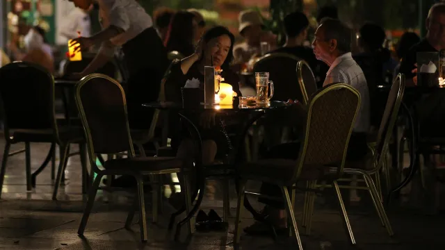 La gente se sienta con velas en un café durante la Hora del Planeta en Hanoi, Vietnam. Foto: EFE