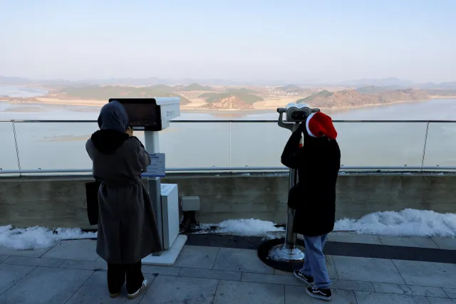 Personas miran una ciudad de Corea del Norte desde un Starbucks