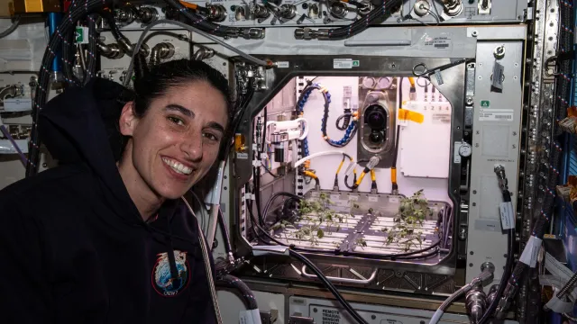 Astronauta de NASA posa frente al “Hábitat Avanzado de Plantas”