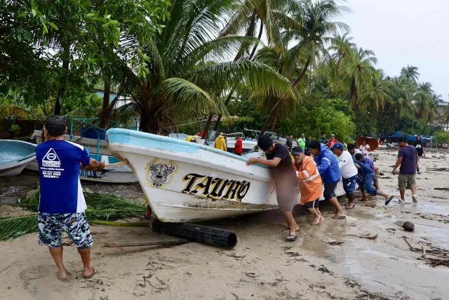 Pescadores mueven lancha en Puerto Escondido