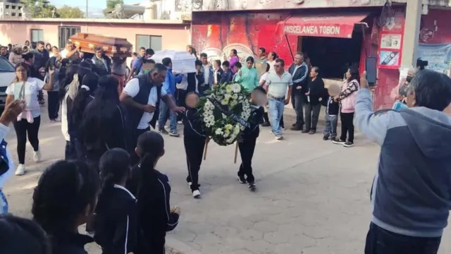 Compañeros se despiden del pequeño Alberto en la escuela Tierra y Libertad de Ixcaquixtla