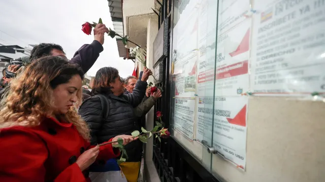 Personas ponen flores en la fachada de la Embajada de Cuba este miércoles, en Quito, Ecuador. Foto: EFE