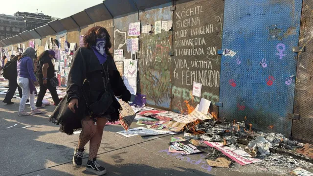 Mujer pasando por vallas intervenidas