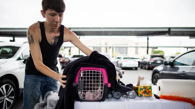 Un residente prepara a su gato y sus cosas para desalojar la zona. 