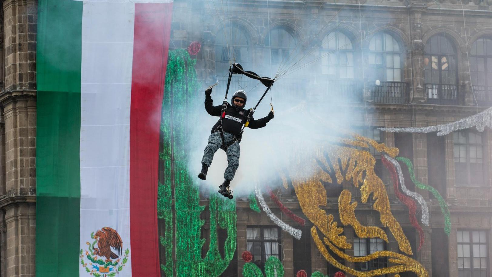 Parachutists descending over a public square